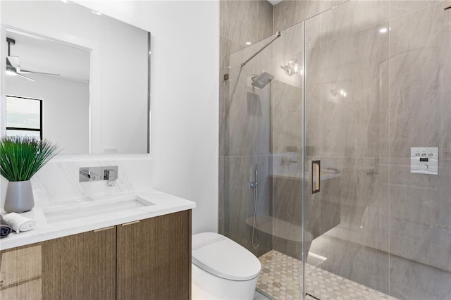 bathroom with ceiling fan, toilet, vanity, and an enclosed shower