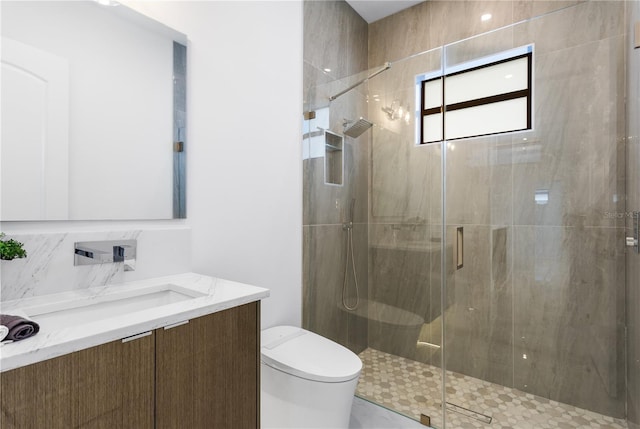 bathroom featuring toilet, a shower with door, and vanity