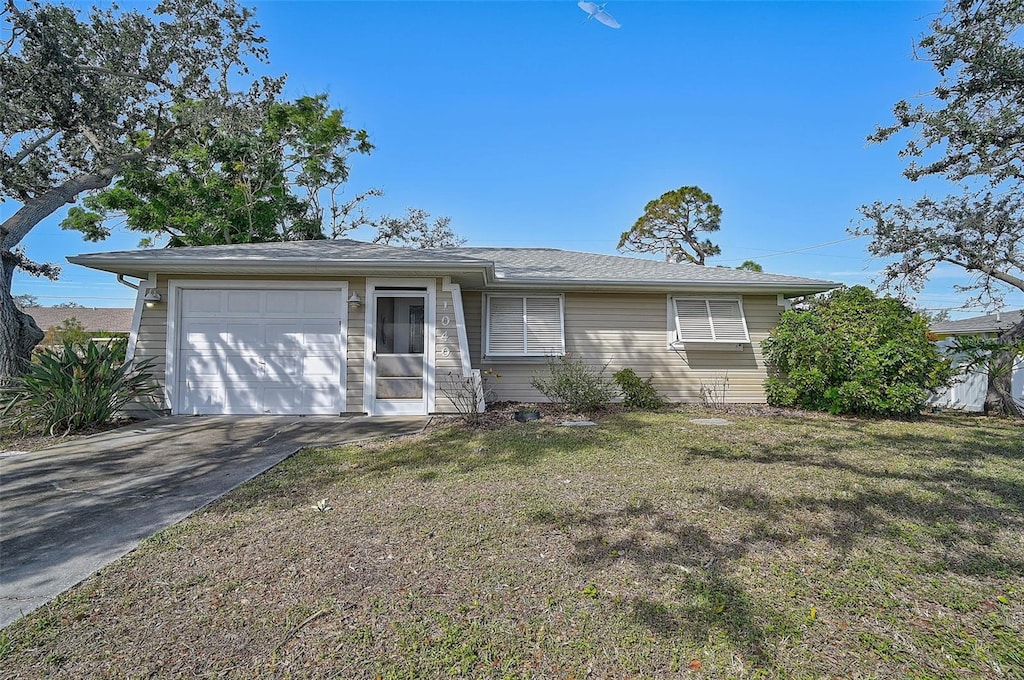 single story home with a garage and a front lawn