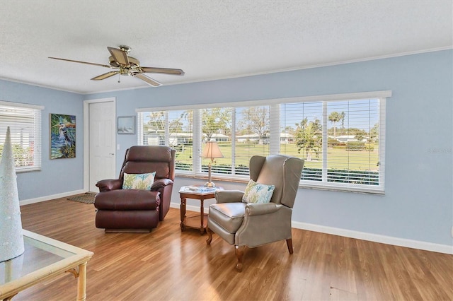 living area featuring plenty of natural light, baseboards, and wood finished floors