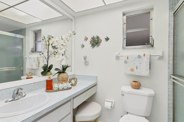 full bathroom with a stall shower, vanity, and toilet