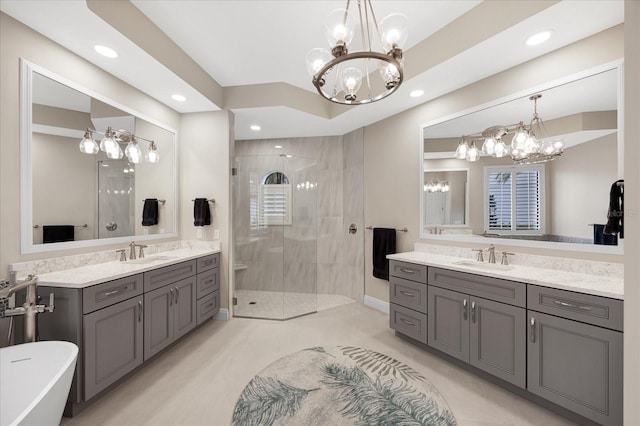 bathroom featuring vanity, a chandelier, and separate shower and tub