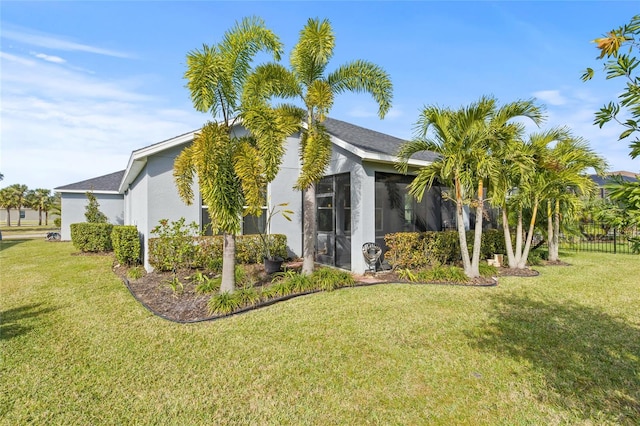 view of side of property with a lawn and a sunroom