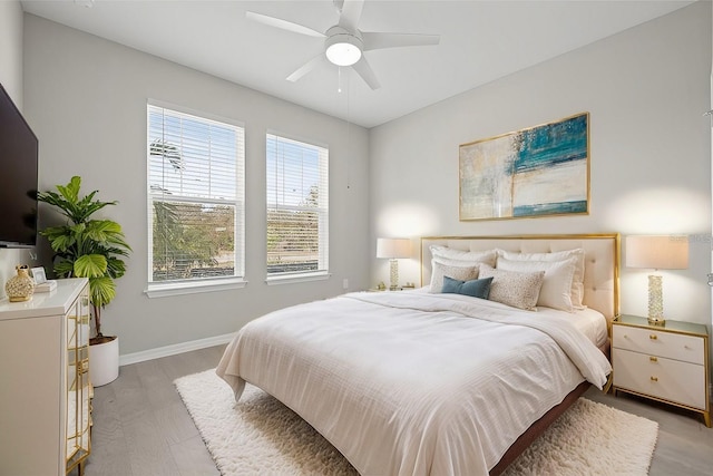 bedroom featuring baseboards, a ceiling fan, and light wood-type flooring