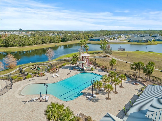 community pool featuring a water view, a patio, and fence