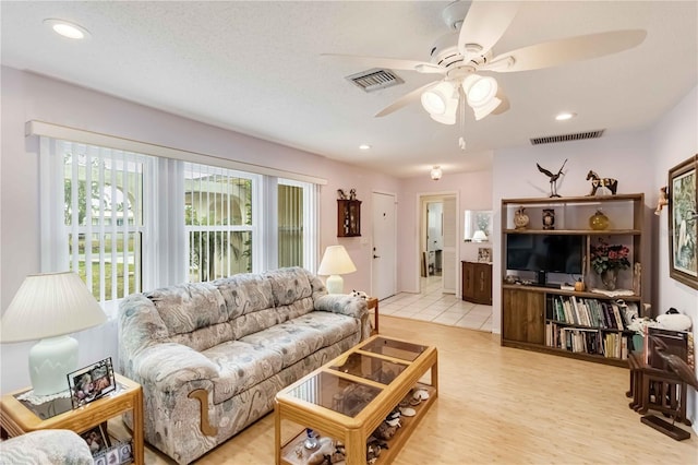 living room with ceiling fan and light wood-type flooring