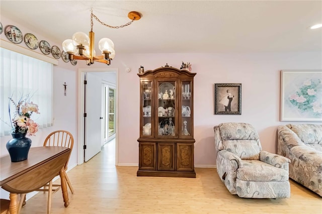 living area featuring light wood-type flooring and an inviting chandelier