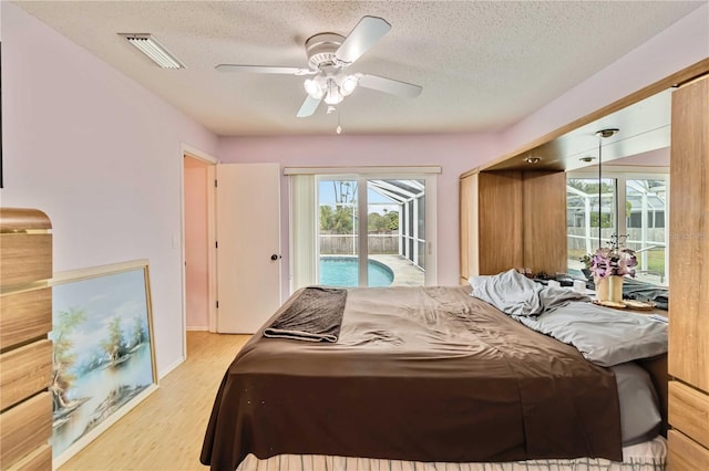 bedroom featuring a textured ceiling, ceiling fan, access to exterior, and light hardwood / wood-style flooring