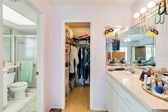 bathroom with vanity, toilet, hardwood / wood-style floors, and an enclosed shower