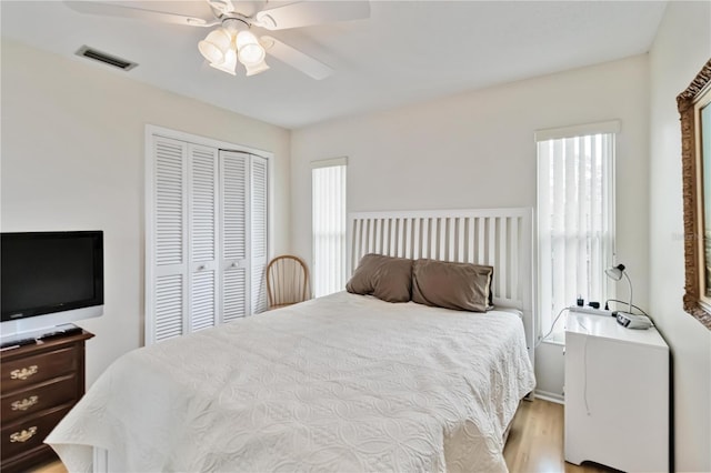 bedroom featuring a closet, light hardwood / wood-style floors, and ceiling fan