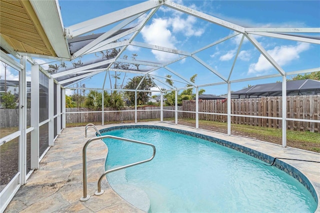 view of swimming pool featuring a lanai and a patio