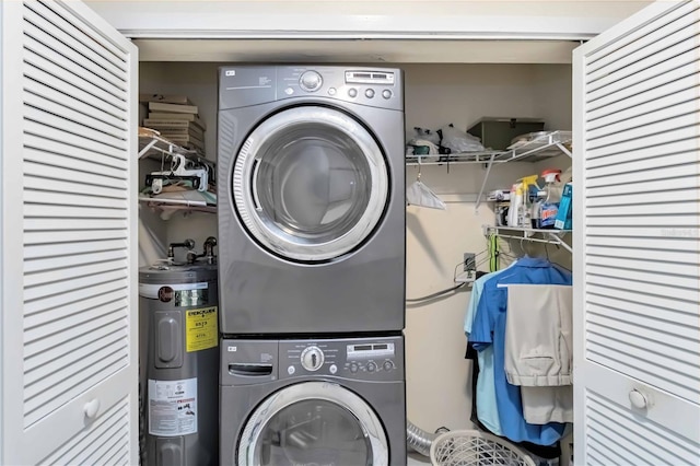 clothes washing area with electric water heater and stacked washer and clothes dryer