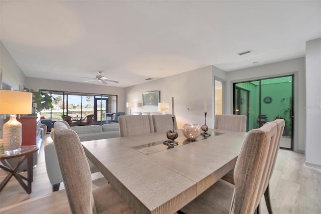 dining space featuring ceiling fan and light wood-type flooring