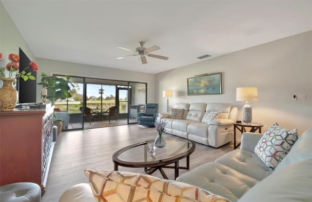 living room featuring ceiling fan and light hardwood / wood-style floors