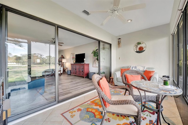 sunroom / solarium featuring ceiling fan