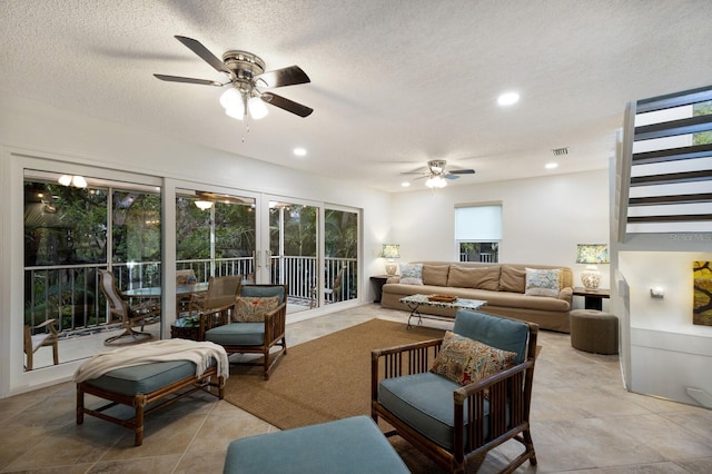 living room featuring a textured ceiling, ceiling fan, and plenty of natural light