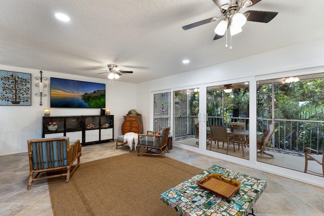 living room with a textured ceiling and ceiling fan