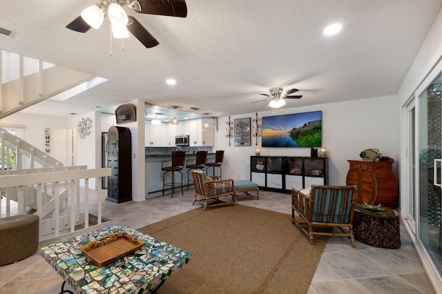 living room featuring a textured ceiling and ceiling fan