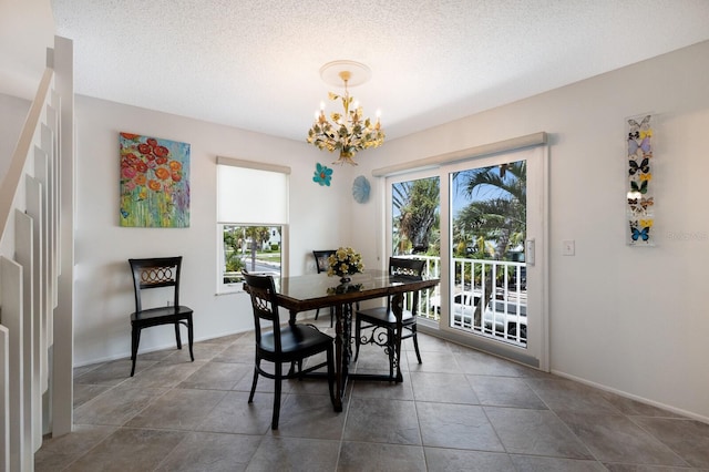 dining room with a textured ceiling and a chandelier