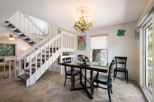 dining room with a healthy amount of sunlight, ceiling fan with notable chandelier, and a textured ceiling