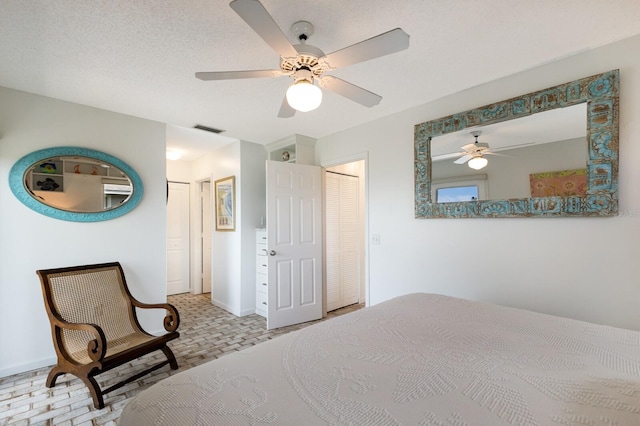 bedroom featuring ceiling fan and a textured ceiling