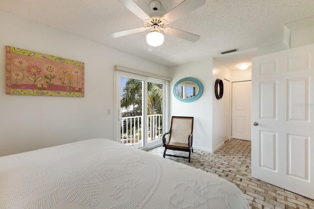 bedroom featuring ceiling fan, a textured ceiling, and access to exterior