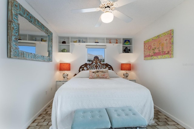 bedroom with ceiling fan and a textured ceiling