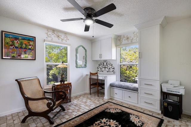 sitting room featuring a textured ceiling, ceiling fan, and plenty of natural light