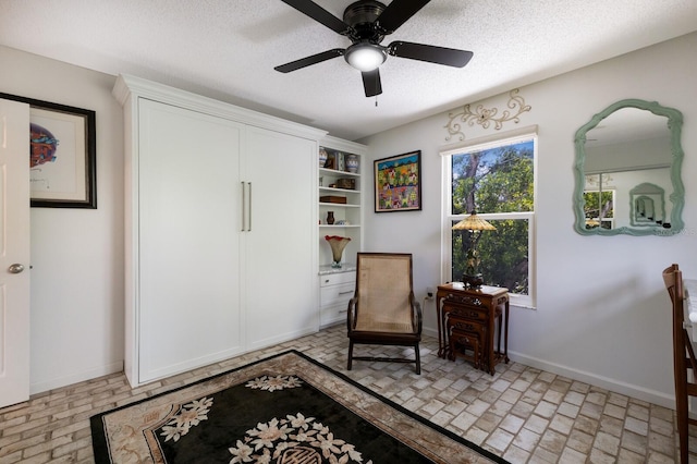 sitting room featuring a textured ceiling and ceiling fan