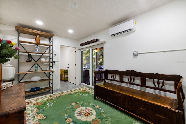 interior space with a textured ceiling and a wall mounted AC