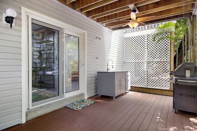 wooden terrace featuring ceiling fan and sink