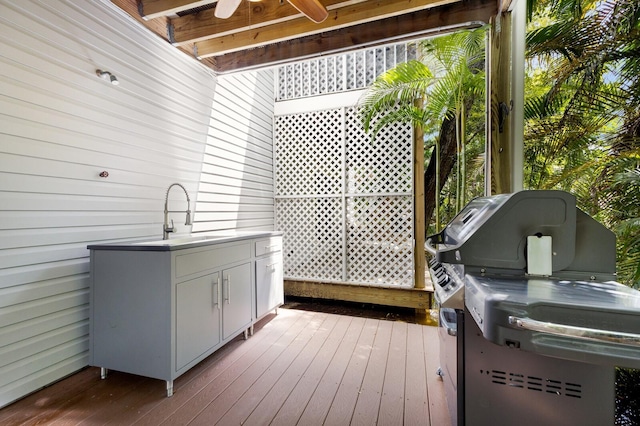 wooden terrace with sink, ceiling fan, and an outdoor kitchen