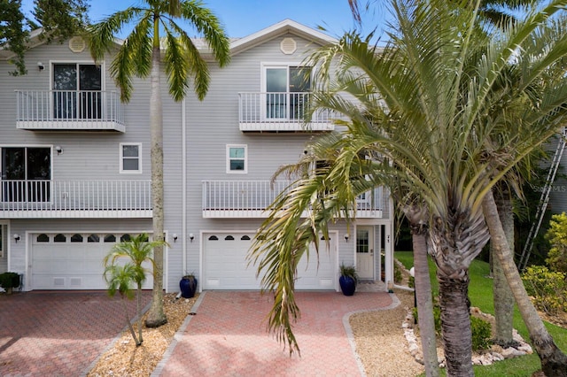 raised beach house featuring a balcony and a garage