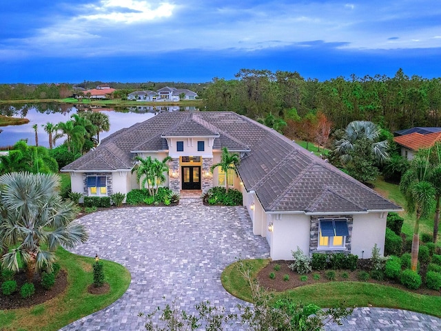 mediterranean / spanish home featuring a water view and french doors