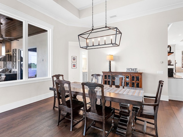 dining room featuring ceiling fan, crown molding, dark hardwood / wood-style floors, and a tray ceiling