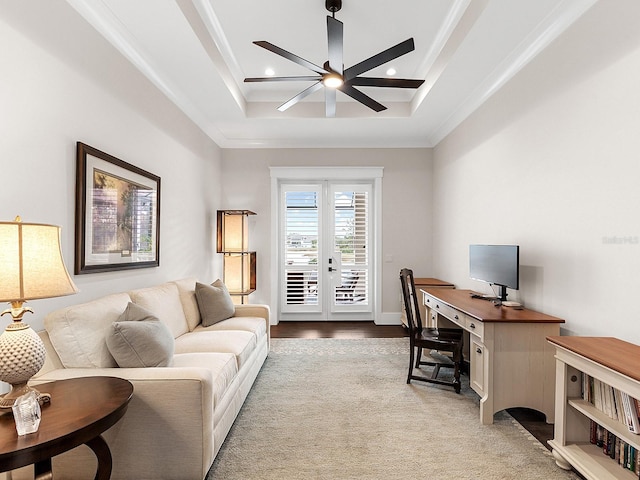 office area featuring ceiling fan, a tray ceiling, crown molding, and light hardwood / wood-style flooring