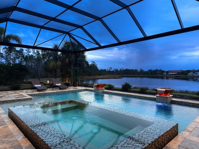 pool at dusk featuring glass enclosure, an in ground hot tub, a water view, and a patio