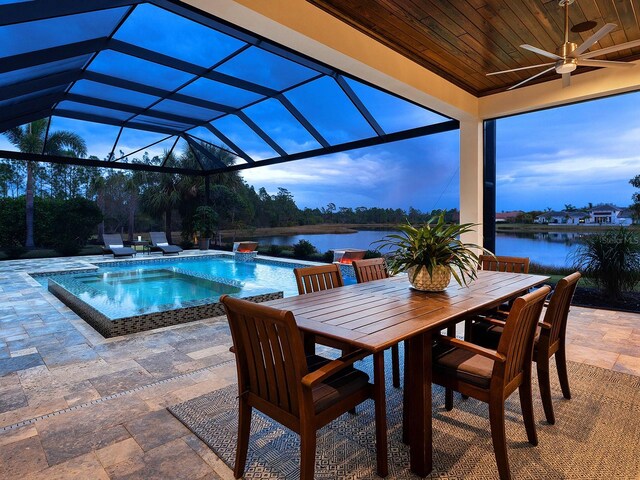 view of pool featuring a water view, ceiling fan, a patio area, and glass enclosure