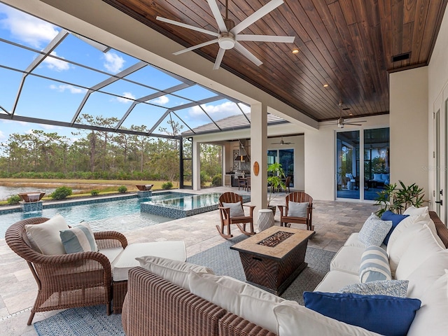 view of pool with a patio area, glass enclosure, ceiling fan, and an outdoor living space with a fire pit