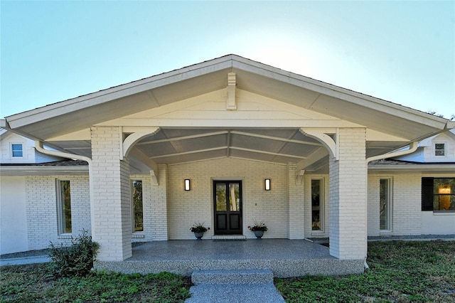 view of exterior entry with a patio area