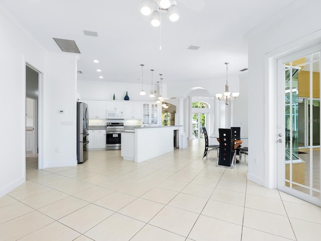 kitchen featuring a center island, white cabinetry, hanging light fixtures, and appliances with stainless steel finishes