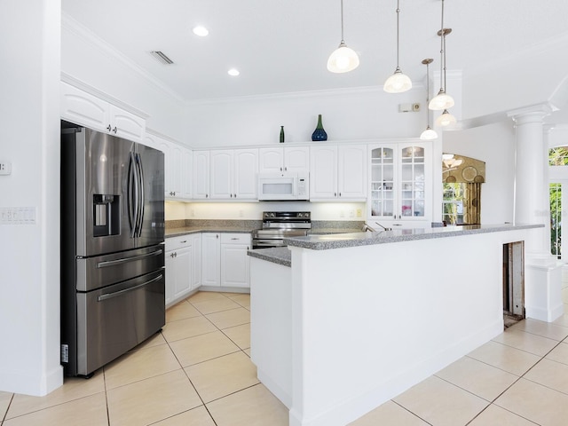 kitchen featuring decorative columns, hanging light fixtures, light tile patterned floors, white cabinets, and stainless steel appliances