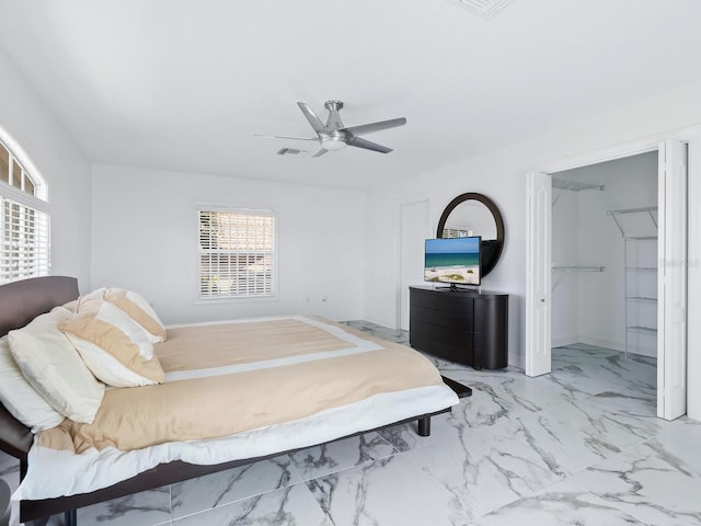 bedroom featuring ceiling fan, multiple windows, a closet, and a walk in closet