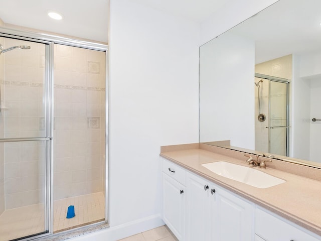 bathroom with an enclosed shower, vanity, and tile patterned flooring