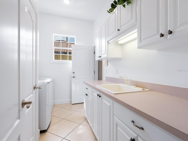 laundry area featuring sink, independent washer and dryer, cabinets, and light tile patterned floors