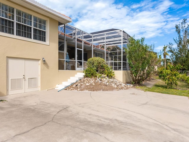 rear view of house with a patio area and a lanai