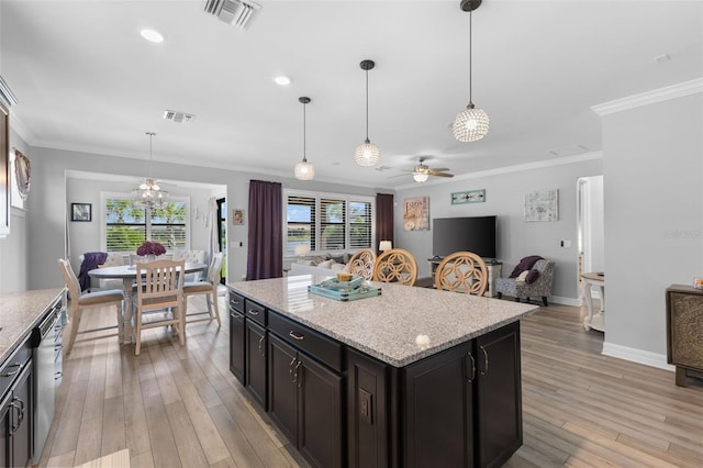 kitchen featuring ceiling fan, pendant lighting, ornamental molding, and a kitchen island