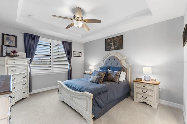 carpeted bedroom featuring a raised ceiling, ceiling fan, and ornamental molding