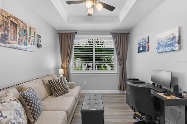 office featuring ornamental molding, a raised ceiling, ceiling fan, and light hardwood / wood-style floors