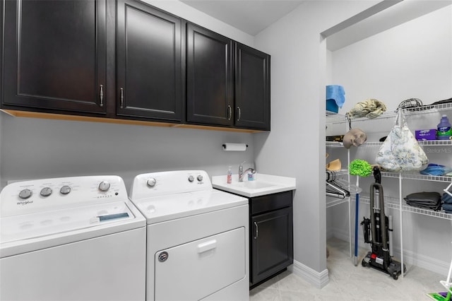 washroom with washer and dryer, cabinets, light tile patterned flooring, and sink